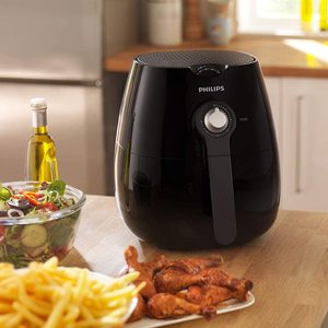 Philips HD9220/20 Air Fryer next to fried food.